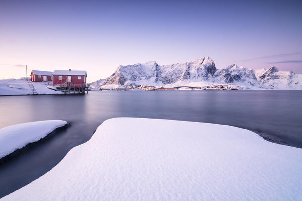 The colors of dawn frames the fishermen houses surrounded by frozen sea Sakrisøy Reine Nordland Lofoten Islands Norway Europe