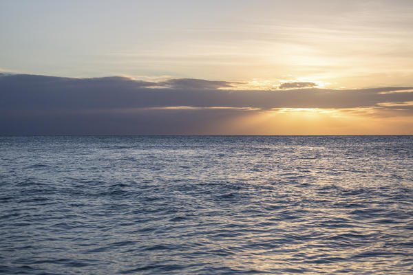 The last rays of sun on waves in the clear water of the Caribbean sea Antigua and Barbuda Leeward Island West Indies