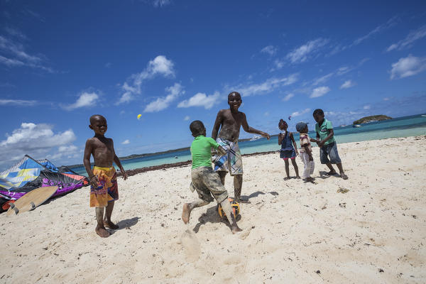 Children play on the beach surrounded by turquoise Caribbean Sea Green Island Antigua and Barbuda Leeward Island West Indies