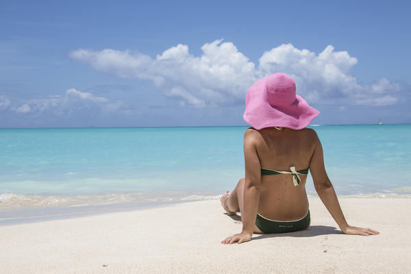 Lady on the sand surrounded by the turquoise Caribbean sea Jolly Beach Antigua and Barbuda Leeward Island West Indies