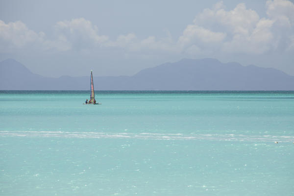 A catamaran in the crystalline waters of the Caribbean Sea Jolly Beach Antigua and Barbuda Leeward Island West Indies