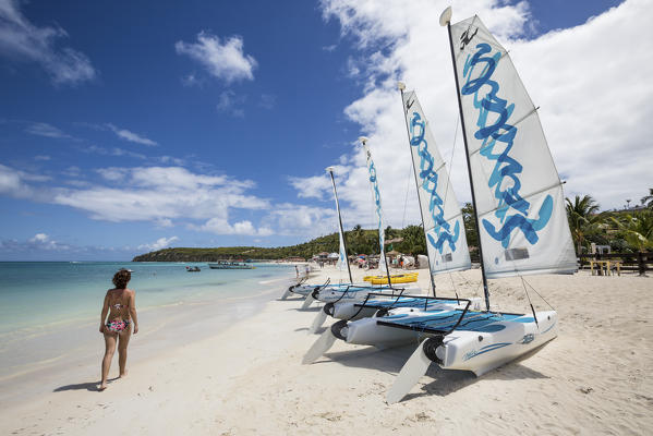 A tourist on the sandy beach equipped with catamarans Dickenson Bay Caribbean Antigua and Barbuda Leeward Island West Indies