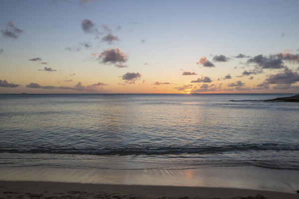 The colors of sunset are reflected on the shore Hawksbill Bay Caribbean Antigua and Barbuda Leeward Islands West Indies