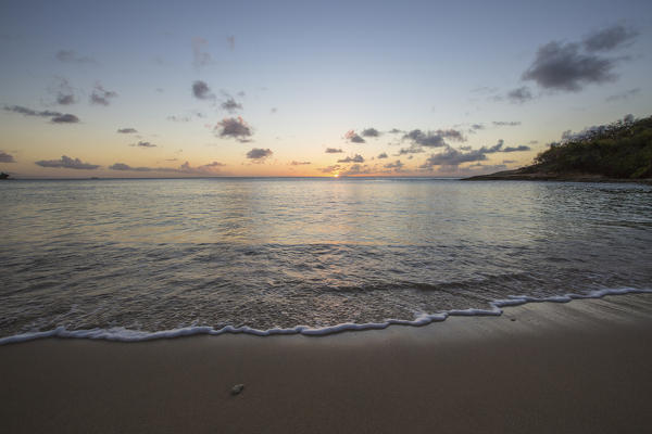 The colors of sunset are reflected on the shore Hawksbill Bay Caribbean Antigua and Barbuda Leeward Islands West Indies
