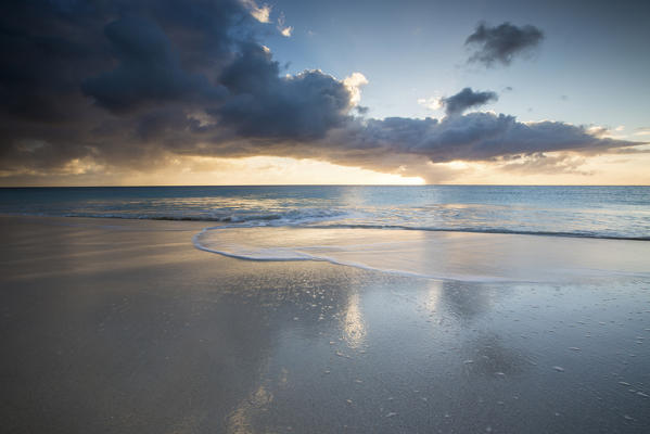 The colors of sunset are reflected on the shore of Ffryers Beach Caribbean Antigua and Barbuda Leeward Islands West Indies