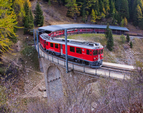The Bernina Express passing on the bridge in Privilasco, Val Poschiavo, Switzerland Europe