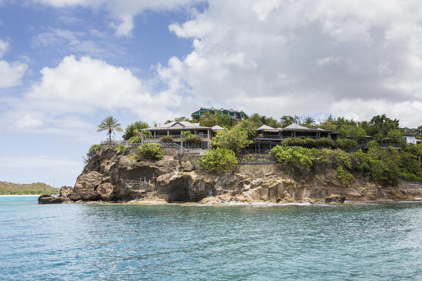 The turquoise Caribbean sea and a tourist resort seen from a boat tour Antigua and Barbuda Leeward Islands West Indies