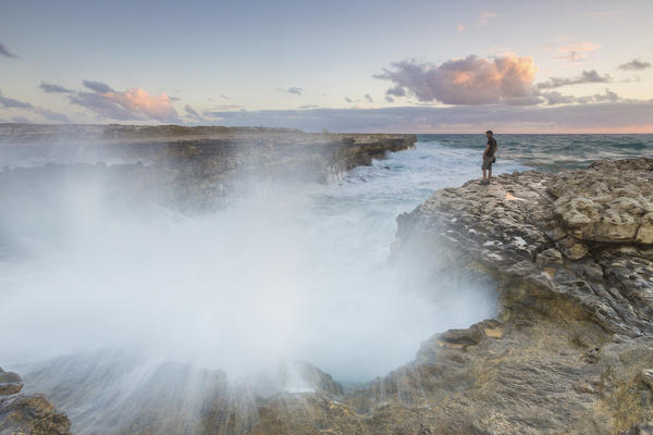 Sunset on the cliffs of Devil's Bridge submerged by crashing waves Caribbean Antigua and Barbuda Leeward Islands West Indies