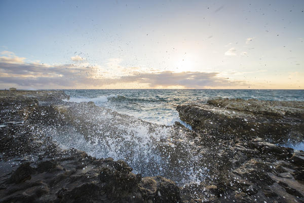 Sunset on the cliffs of Devil's Bridge submerged by crashing waves Caribbean Antigua and Barbuda Leeward Islands West Indies