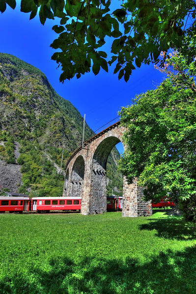 The Bernina Express under the viaduct in Brusio, Val Poschiavo, Switzerland Europe