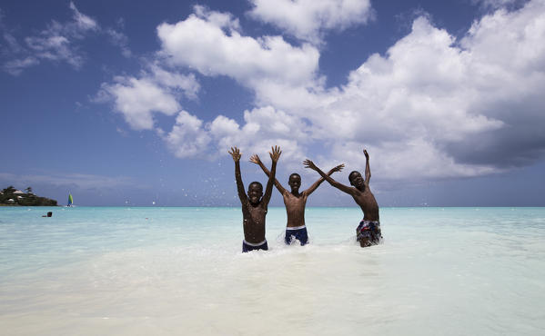 Children smile in the turquoise waters of Caribbean Sea The Nest Antigua and Barbuda Leeward Islands West Indies