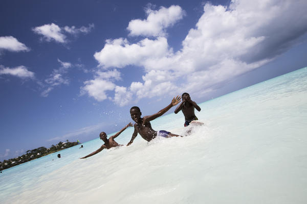 Children smile in the turquoise waters of Caribbean Sea The Nest Antigua and Barbuda Leeward Islands West Indies