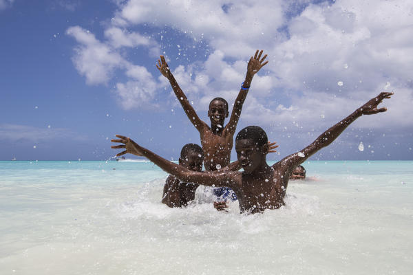Children smile in the turquoise waters of Caribbean Sea The Nest Antigua and Barbuda Leeward Islands West Indies