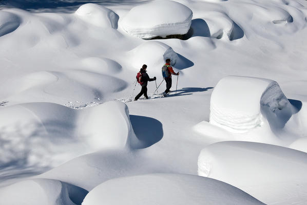 Men wearing snowshoes walking in Val Febraro after an hearly snowfall, Valchiavenna  Spluga Valley, Lombardy Italy Europe