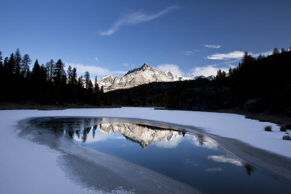 The half frozen Lake Mufule reflecting Sasso Moro, Valmalenco, Lombardy Valtellina, Italy Europe