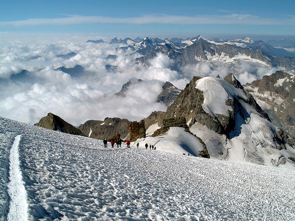 Mountaineers along the normal route are now approaching the summit of the Gran Paradiso. On the right the Ciarforon peak, Aosta Valley, Italy Europe