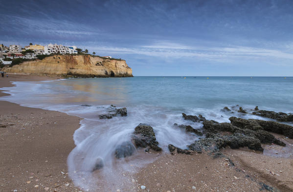 Ocean waves crashing on rocks and beach surrounding Carvoeiro village at sunset Lagoa Municipality Algarve Portugal Europe