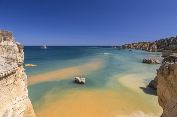 Canoes in the turquoise water of the Atlantic Ocean surrounding Praia Dona Ana beach Lagos Algarve Portugal Europe