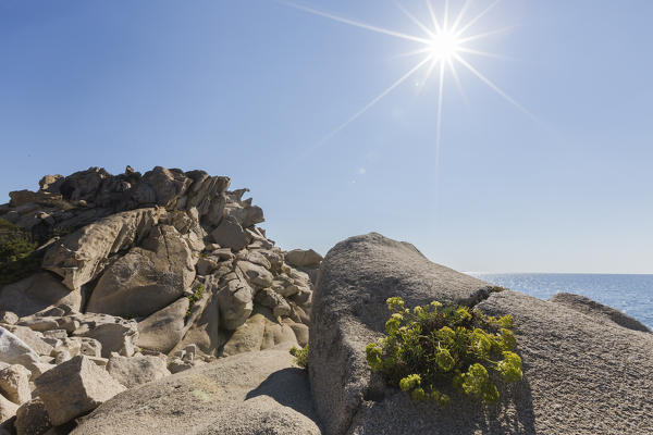 Sunbeams on the rocks eroded by wind framing the blue sea Punta Molentis Villasimius Cagliari Sardinia Italy Europe