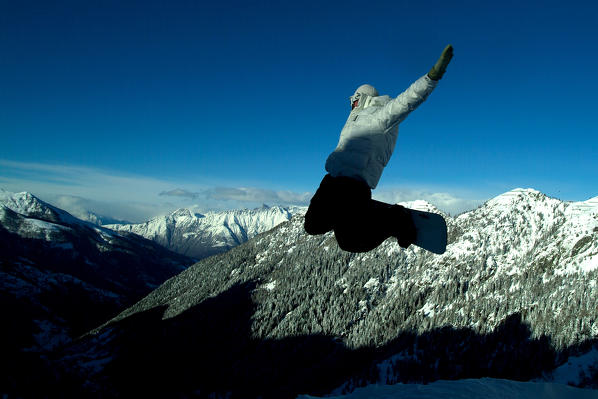 A snowboarder jump in Pescegallo, Valtellina, Lombardy Italy Europe