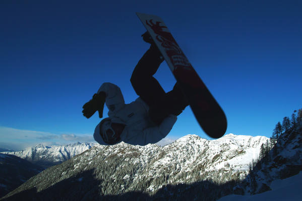 A snowboarder jump in Pescegallo, Valtellina, Lombardy Italy Europe