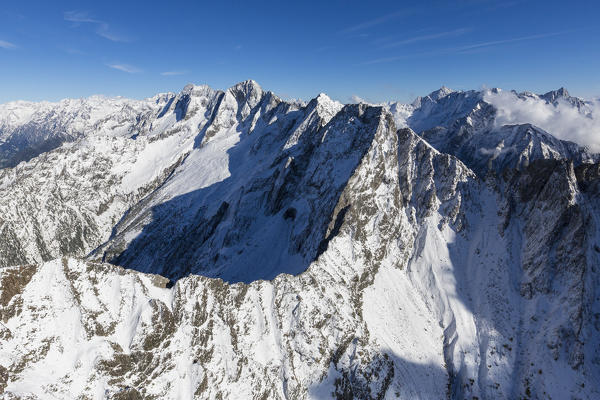 Aerial view of the snowy peaks and ridges in a sunny day of autumn Chiavenna Valley Valtellina Lombardy Italy Europe