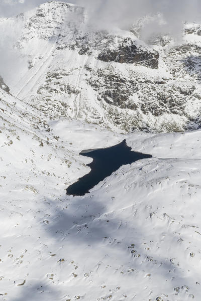 Aerial view of the blue Lake Croce framed by snowy peaks Spluga Valley Valtellina Lombardy Italy Europe