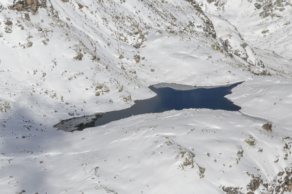 Aerial view of the blue Lake Croce framed by snowy peaks Spluga Valley Valtellina Lombardy Italy Europe