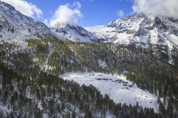 Aerial view of the alpine village of Laguzzola framed by woods and snowy peaks Spluga Valley Valtellina Lombardy Italy Europe