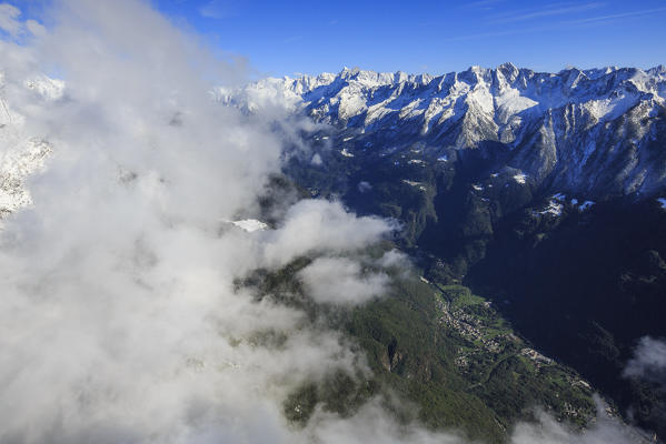 Aerial view of snowy peaks and green woods in a sunny autumn day Bregaglia Valley Switzerland Europe