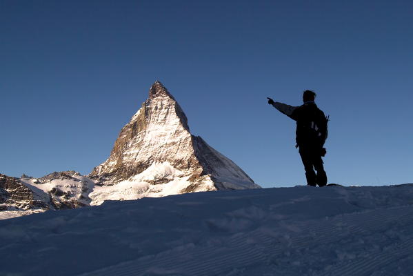 A hiker by the Station of Gornergrat with the Matterhorn summit in the background at sunrise, Canton of Valais, Switzerland Europe