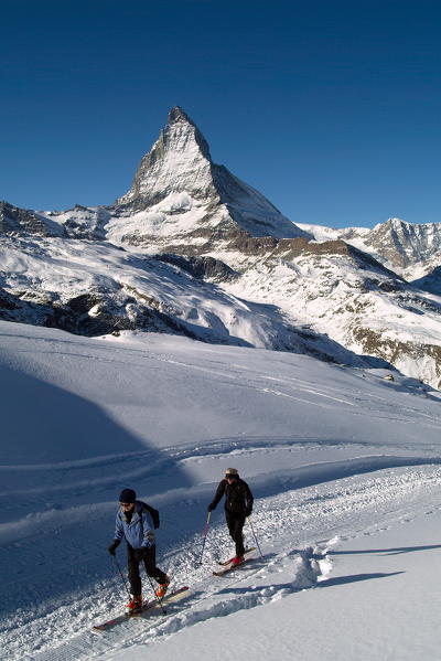 Two skiers by the Station of Gornergrat with the Matterhorn summit in the background, Canton of Valais, Switzerland Europe