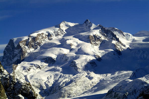 The massive shape of the Mount Rosa, Monte Rosa, its summits and glaciers overtopping 4.000 m, Canton of Valais, Switzerland Europe