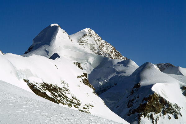 High above Zermatt, along the Swiss-Italian border, is a very high frontier ridge, home of many 4000 meter summits. Two of the these peaks, the Twins of Castor and Pollux are readily accessible as day climbs from Zermatt. Where Castor is longer and all snow and ice, Pollux is mixed with fun rock climbing as you approach the summit - canton of Valais, Switzerland Europe