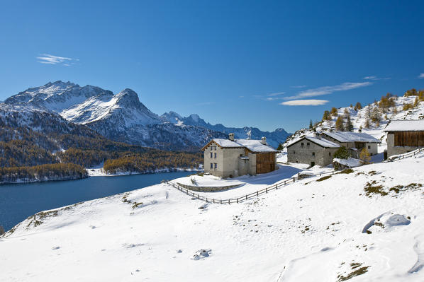 Autumn snow on a group of houses in Spluga, built on a panoramic terrace near the Sils lake in Engadine, Switzerland. Europe