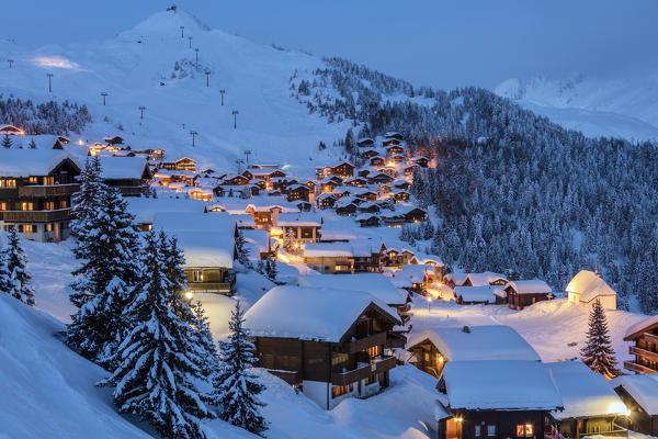Blue dusk on the snowy alpine village surrounded by woods Bettmeralp district of Raron canton of Valais Switzerland Europe