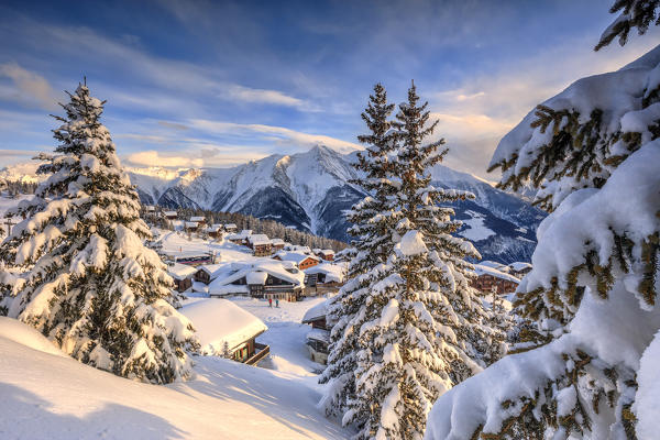 Snowy woods and mountain huts framed by the winter sunset Bettmeralp district of Raron canton of Valais Switzerland Europe