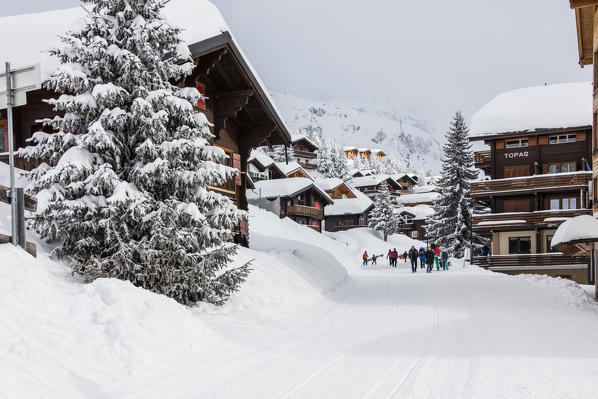 Tourists in the alpine village surrounded by snow and woods Bettmeralp district of Raron canton of Valais Switzerland Europe