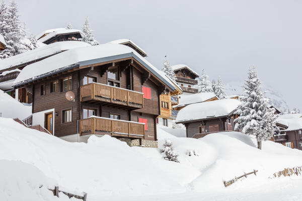 Wooden houses covered with snow surrounded by woods Bettmeralp district of Raron canton of Valais Switzerland Europe