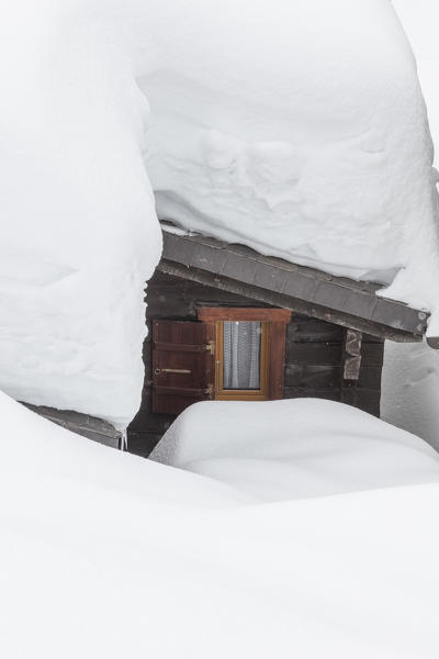 A typical wooden mountain hut submerged by snow Bettmeralp district of Raron canton of Valais Switzerland Europe