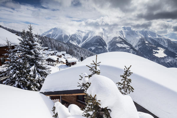 Trees covered with snow frame the typical mountain huts Bettmeralp district of Raron canton of Valais Switzerland Europe