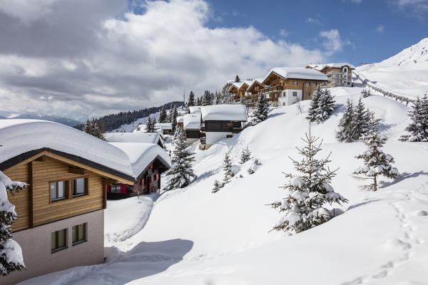 Trees covered with snow frame the typical mountain huts Bettmeralp district of Raron canton of Valais Switzerland Europe