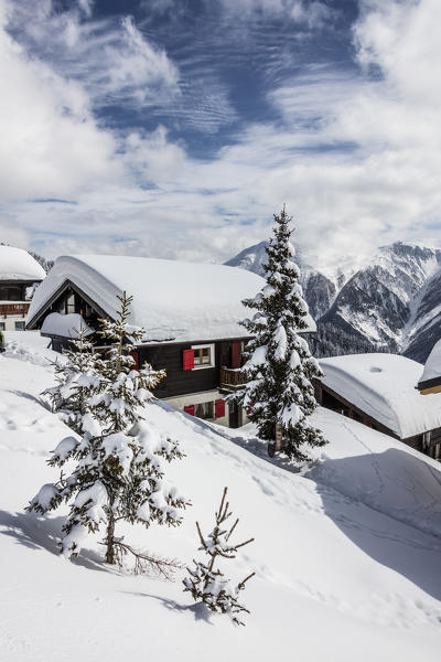 Trees covered with snow frame the typical mountain huts Bettmeralp district of Raron canton of Valais Switzerland Europe