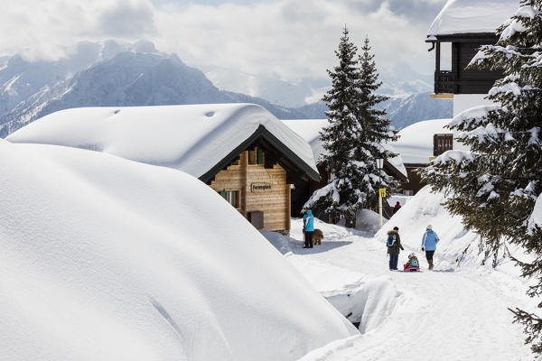People enjoying fresh snow among the typical mountain huts Bettmeralp district of Raron canton of Valais Switzerland Europe