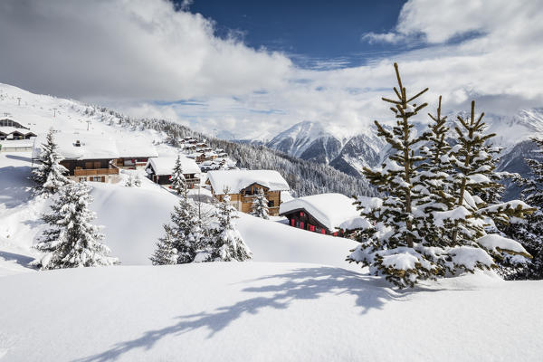 The winter sun shines on the snowy mountain huts and woods Bettmeralp district of Raron canton of Valais Switzerland Europe