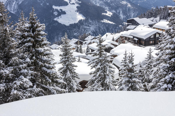 Trees covered with snow frame the typical mountain huts Bettmeralp district of Raron canton of Valais Switzerland Europe