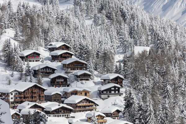 The snowy woods frame the typical mountain huts Bettmeralp district of Raron canton of Valais Switzerland Europe