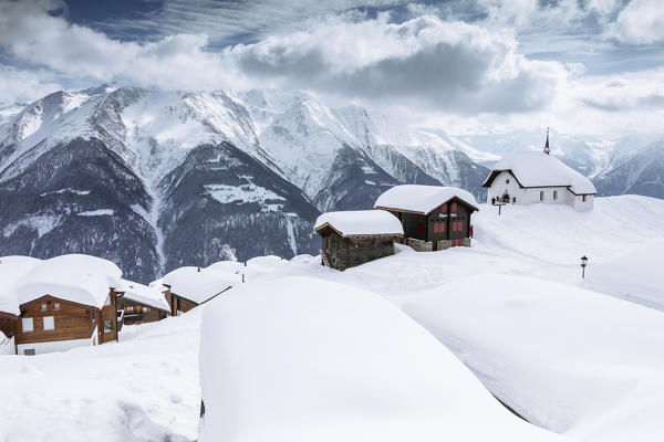 Snow covered mountain huts frame the high peaks Bettmeralp district of Raron canton of Valais Switzerland Europe
