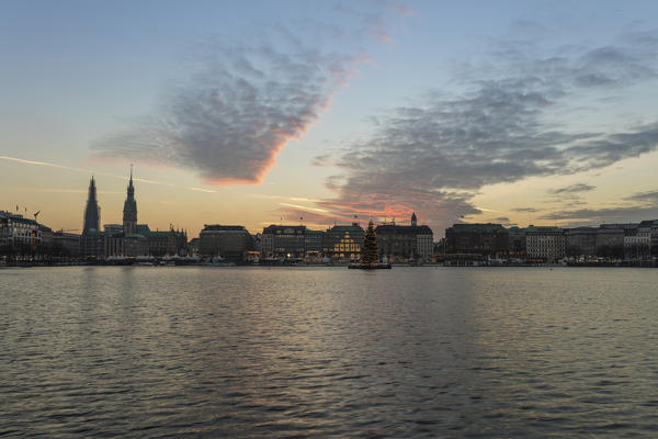 The artificial Inner Alster Lake frames the old buildings and palace of the city center at dusk Hamburg Germany Euope