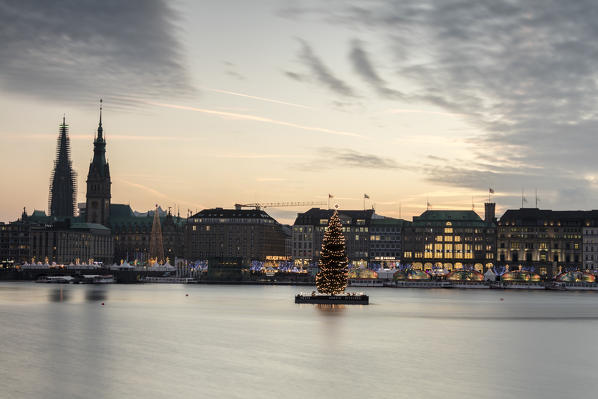 The colors and lights of dusk on Inner Alster Lake with the Christmas Tree suspended in its water Hamburg Germany Europe